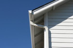 White rain gutter downspout on house. Good photo for home improvement construction or rain gutters.