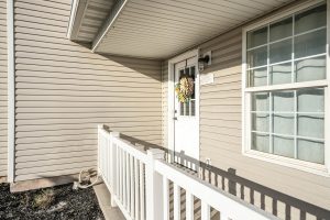 Front door exterior of a house with vinyl wall sidings