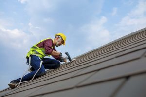 technician installing roofing shingles