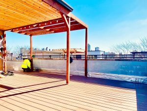 a technician repairing a wood deck on a flat roof